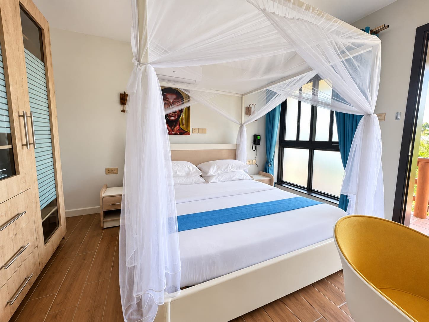 A cottage bedroom with a canopy net and a blue bed runner