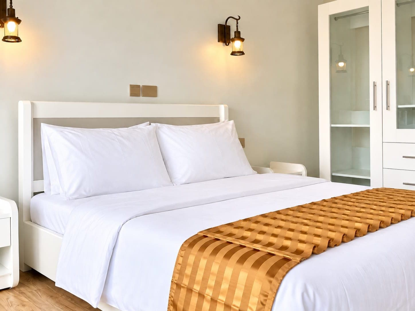 Budget Deluxe room with a gold runner, white wardrobe and lit wall sconces
